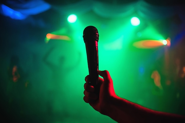 Photo la main de l'homme avec un microphone sur fond d'événement musical