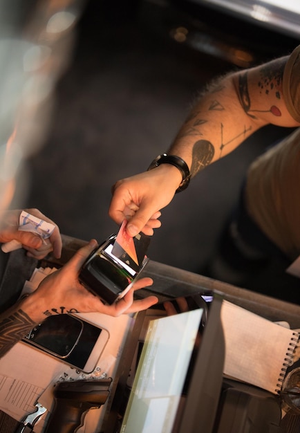 La main de l'homme paie avec une carte de crédit avec un barman dans un bar