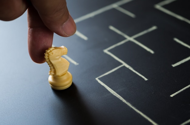 La main de l'homme place les échecs du chevalier au labyrinthe