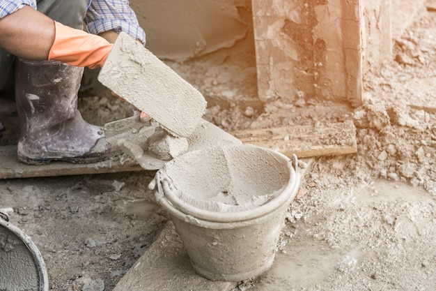 la main de l&#39;homme en plâtrant un mur avec une truelle.