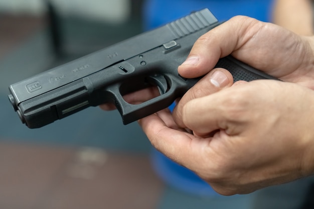 Une main d'homme pratiquant le tir à l'aide d'un modèle de pistolet Glock au champ de tir.