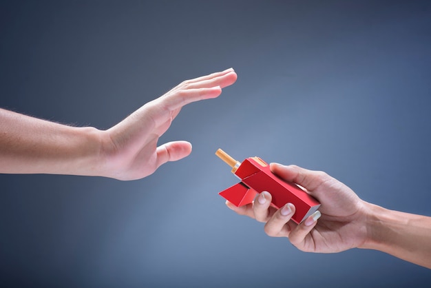 Main d'homme refusant l'offre de cigarettes d'autres personnes