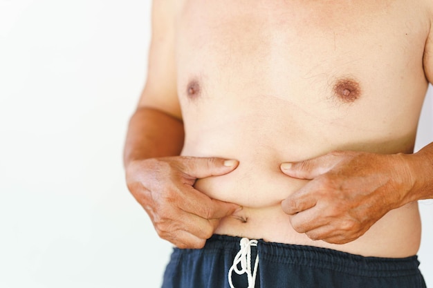 Photo main de l'homme serrant la graisse du ventre accumulation de graisse dans l'abdomen des hommes.