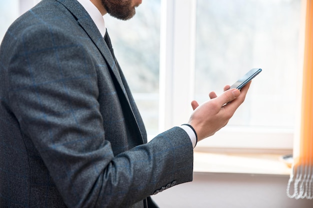 Main d'homme téléphone dans la fenêtre