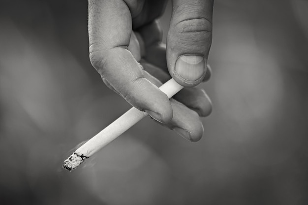 La main de l'homme tenant une cigarette allumée