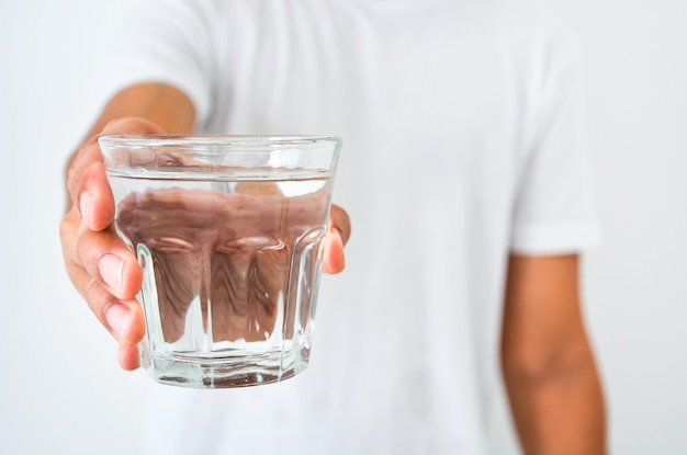 Main d&#39;homme tenant un verre d&#39;eau propre sur fond blanc