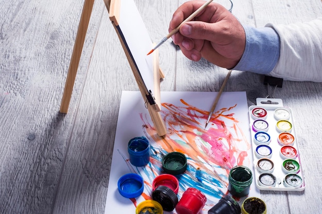 La main d'un homme tient un pinceau pour l'aquarelle