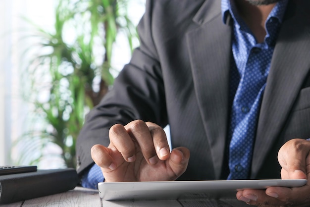 main d'homme travaillant sur une tablette numérique au bureau à l'aide d'un graphique auto-créé