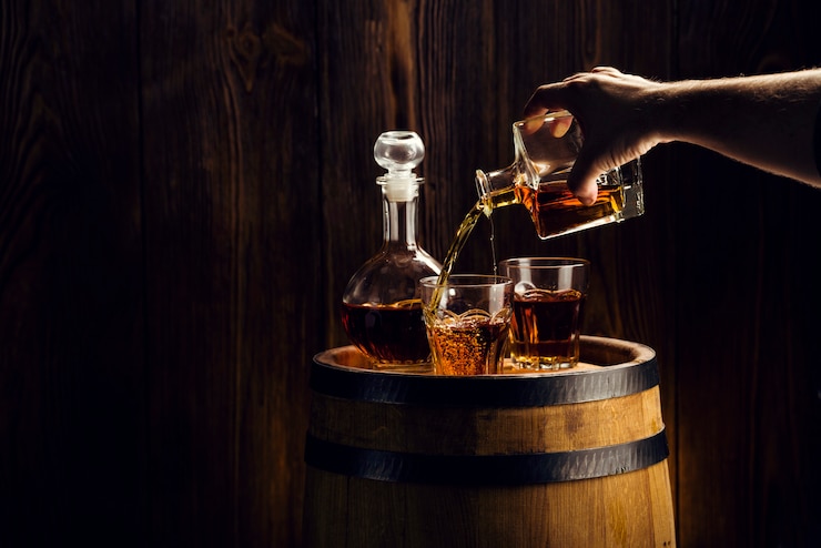 Photo main de l'homme verse une boisson alcoolisée dans un verre