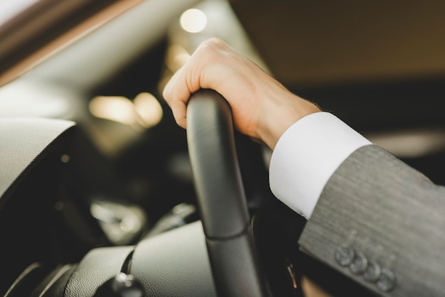 Photo main de l'homme sur le volant dans la voiture