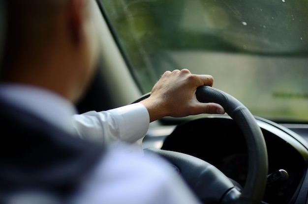 La main de l'homme sur le volant d'une voiture