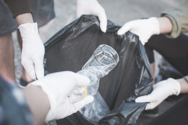 Main humaine ramasser vide de bouteille en plastique sur le parc