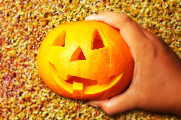 Photo main humaine tenant jack-o-lantern avec fond au sol