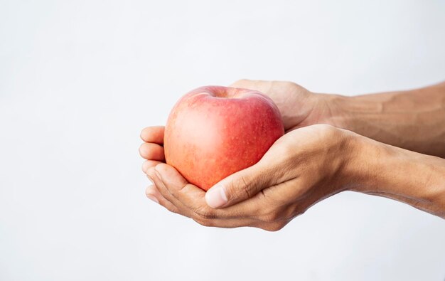 Une main humaine tenant une pomme avec un fond blanc