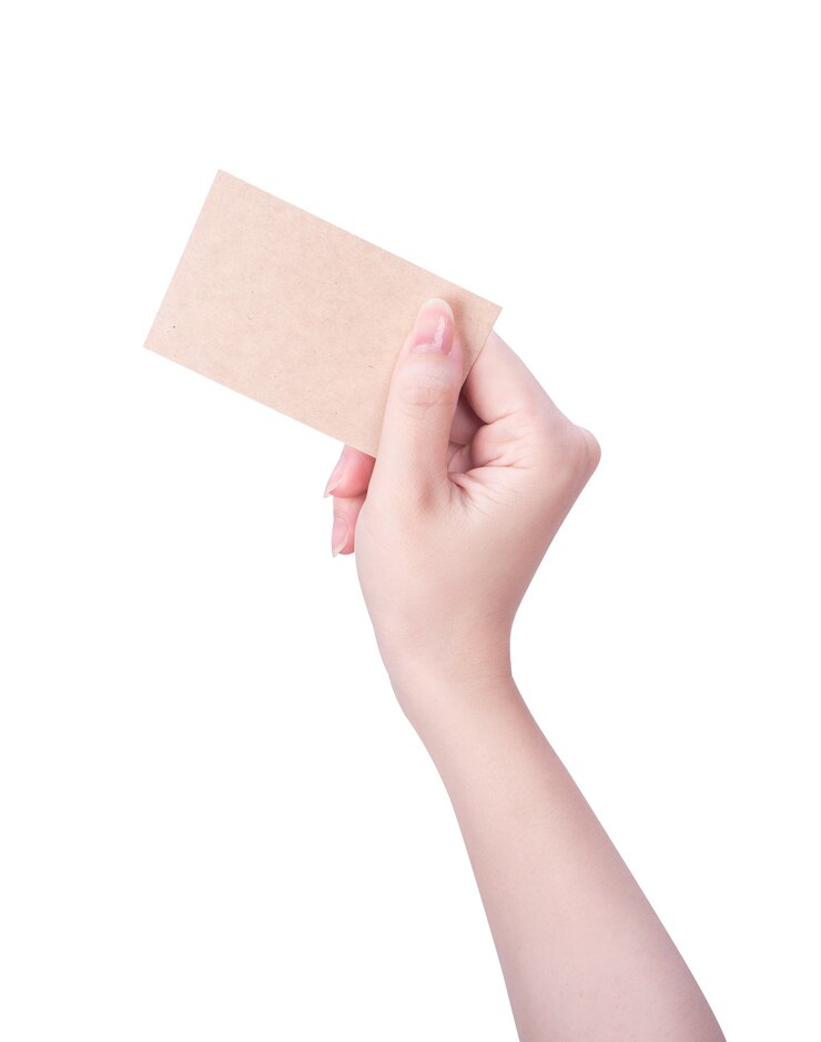 Photo main de jeune femme tenant une carte de papier brun kraft vierge isolée