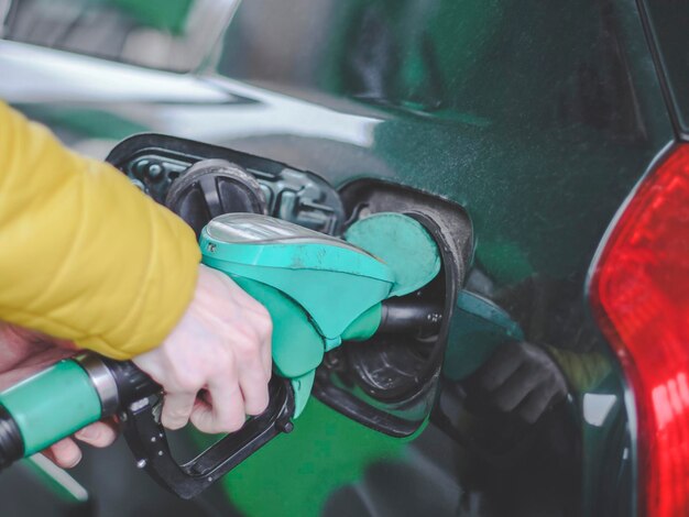 La main d'un jeune homme caucasien remplit la voiture d'essence