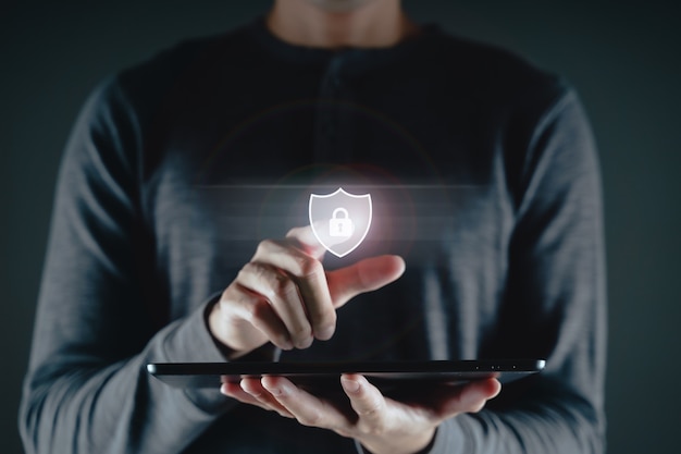 Photo main de jeune homme touchant sur l'icône de cadenas d'écran virtuel. protection des données, confidentialité des informations, cybersécurité, déverrouillage, concept de technologie de mise en réseau internet.