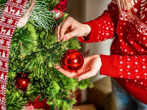 La main avec le jouet d'arbre de Noël décoration d'arbre de Noël agrandi