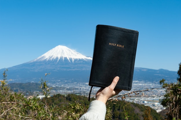 Main Levée Tenant La Sainte Bible Devant Le Mont Fuji Au Japon