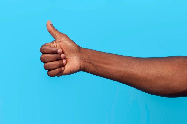 Photo main masculine africaine montrant comme sur le bleu isolé fond gros plan