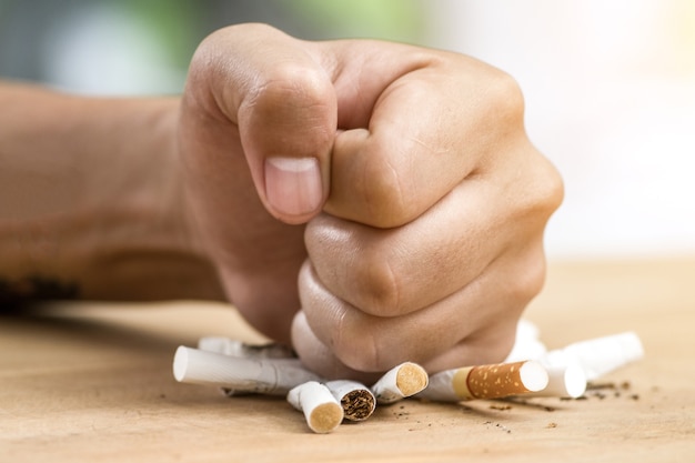 Photo main masculine détruisant des cigarettes - concept d'arrêter de fumer