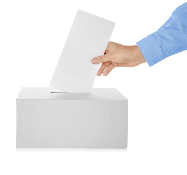 Main masculine mettant le bulletin de vote dans la boîte sur fond blanc