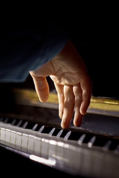 Une main masculine sur le piano.