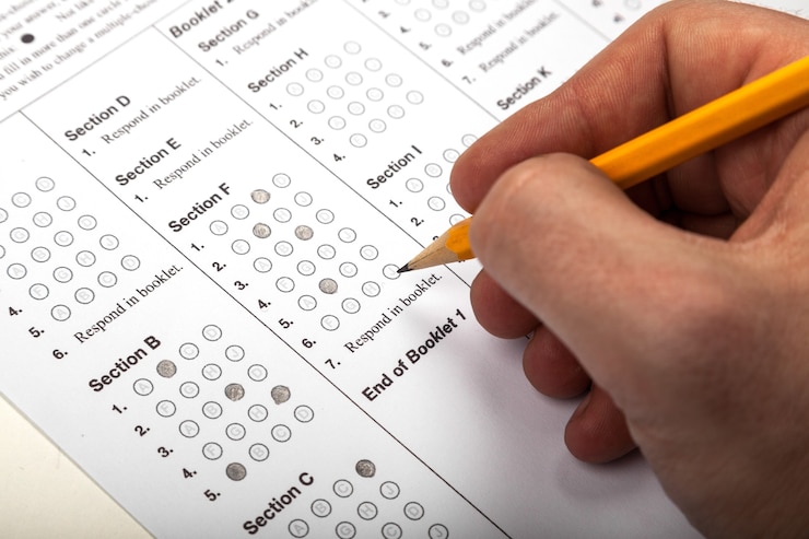 Photo main masculine remplissant des réponses avec un crayon sur un test à choix multiples