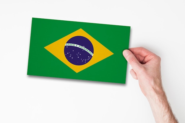 Main masculine tenant le drapeau du brésil