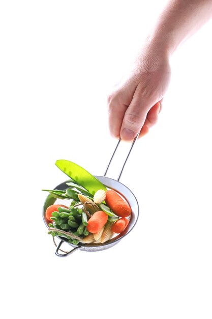 La main masculine tient des légumes sur un fond blanc, une alimentation saine des aliments végétaliens, des aliments crus