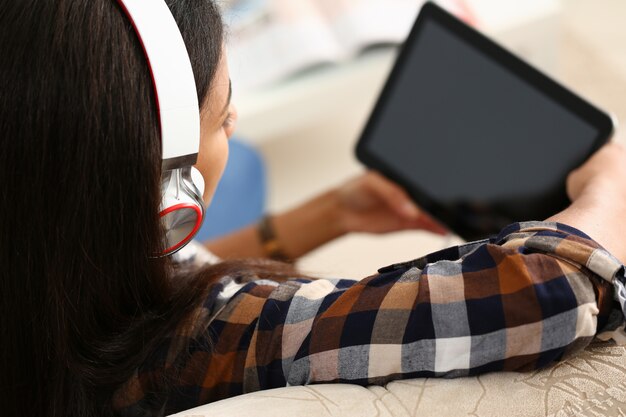 La main masculine tient la tablette dans le cadre de la maison tout en