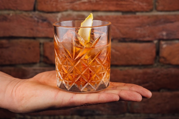 La main masculine tient le verre de whisky