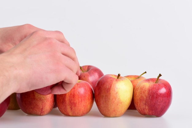 La main masculine touche des pommes rouge clair Fruits de couleur vive