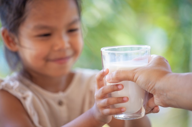 Main mère donnant un verre de lait à son enfant avec soin et amour