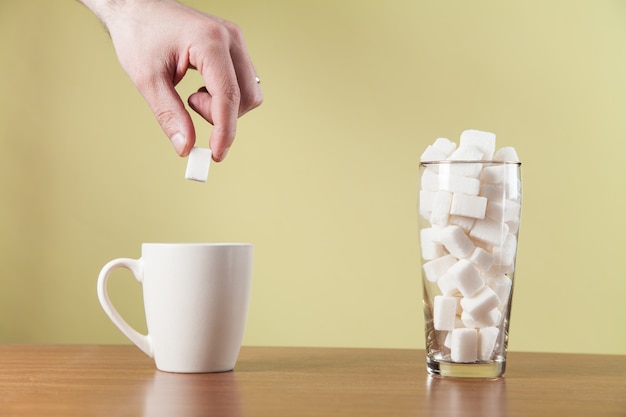 La Main Met Des Cubes De Sucre Sur Une Tasse à Café.