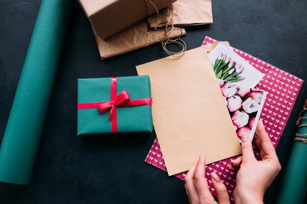 Main mettant la carte de voeux dans une enveloppe