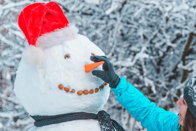 Main mettre le nez de carotte au bonhomme de neige close up concept