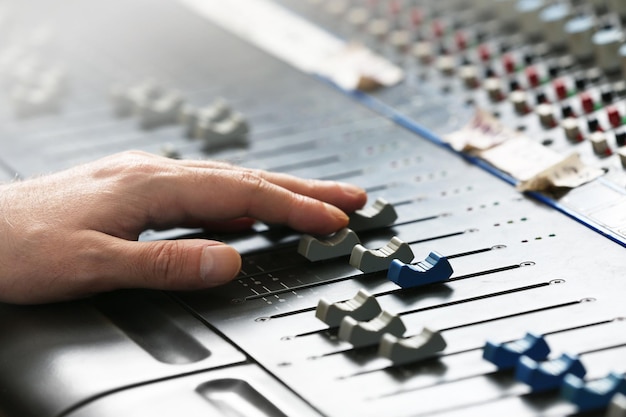 Photo main sur le mixeur dans un studio d'enregistrement en gros plan