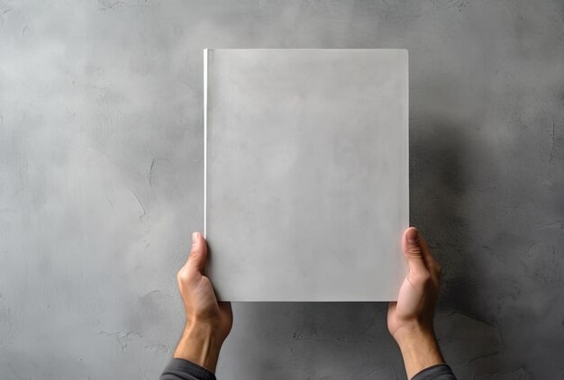 une main montre un papier blanc vierge sur une surface en béton gris dans le style des livres et des portefeuilles