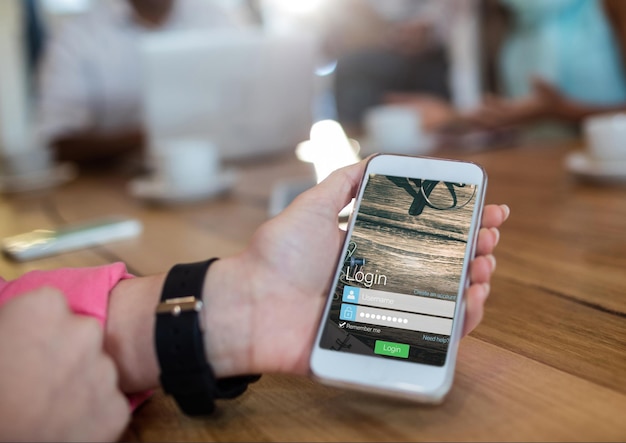 main avec montre et téléphone avec écran de connexion dans une cafétéria