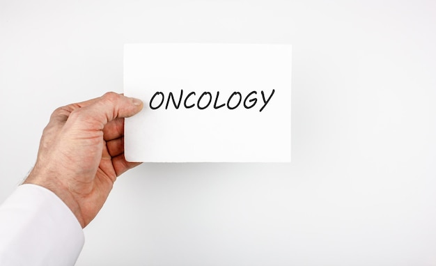 Main avec une notice avec le mot ONCOLOGIEConcept de diagnostic d'oncologieUne tumeur maligne ou bénigne un symptôme d'oncologie ou un diagnostic