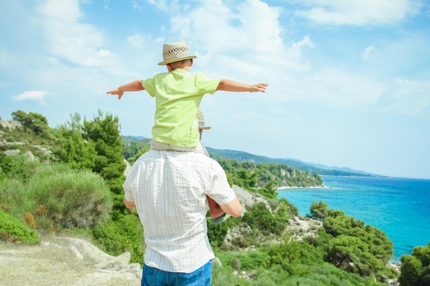 Une main de parents et d'enfants heureux en mer en arrière-plan de voyage en grèce