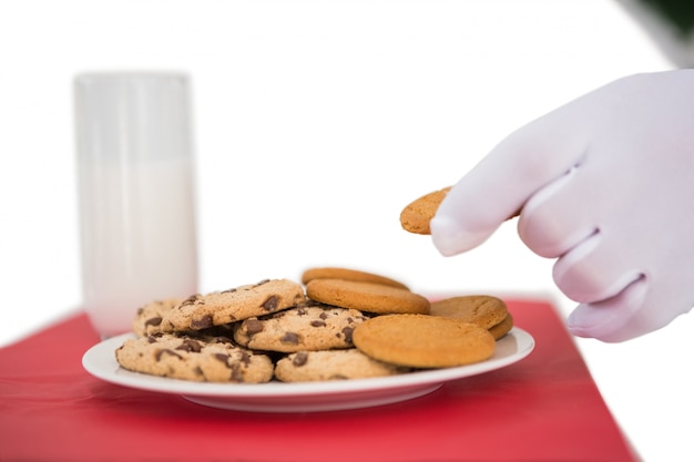 Main de père Noël prenant cookie