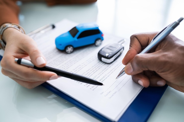 Photo main de la personne signant le contrat de prêt automobile