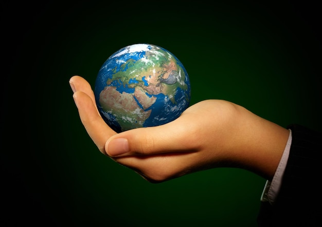 La main de la personne tient le globe.