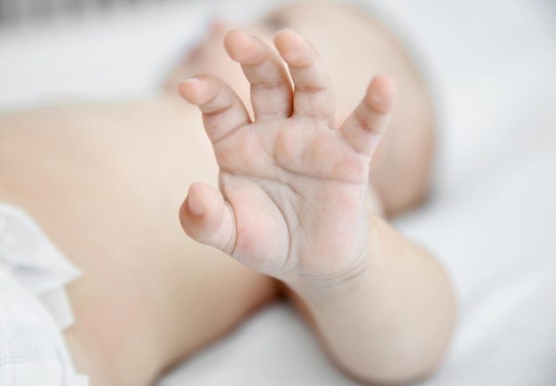 Main de petit bébé dans le berceau libre