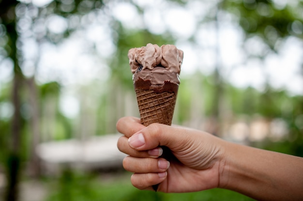 Main photos et glace au chocolat, concept alimentaire avec espace de copie