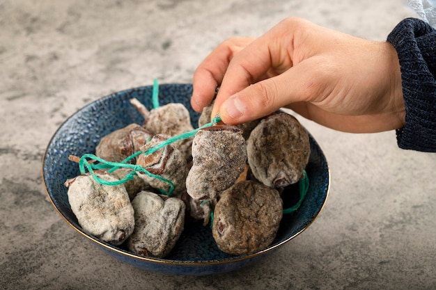 Main prenant des fruits de kaki séchés sur la surface de la pierre