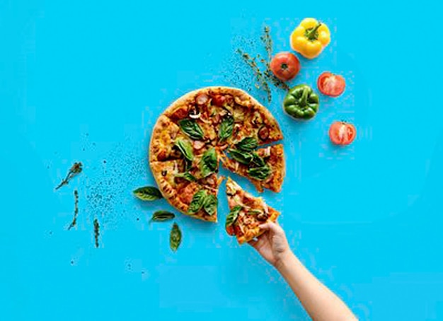 La main prenant une tranche de pizza de cuisine italienne