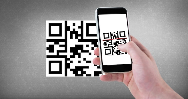 La main recadrée scannant le code qr avec un téléphone intelligent avec un espace de copie sur fond gris